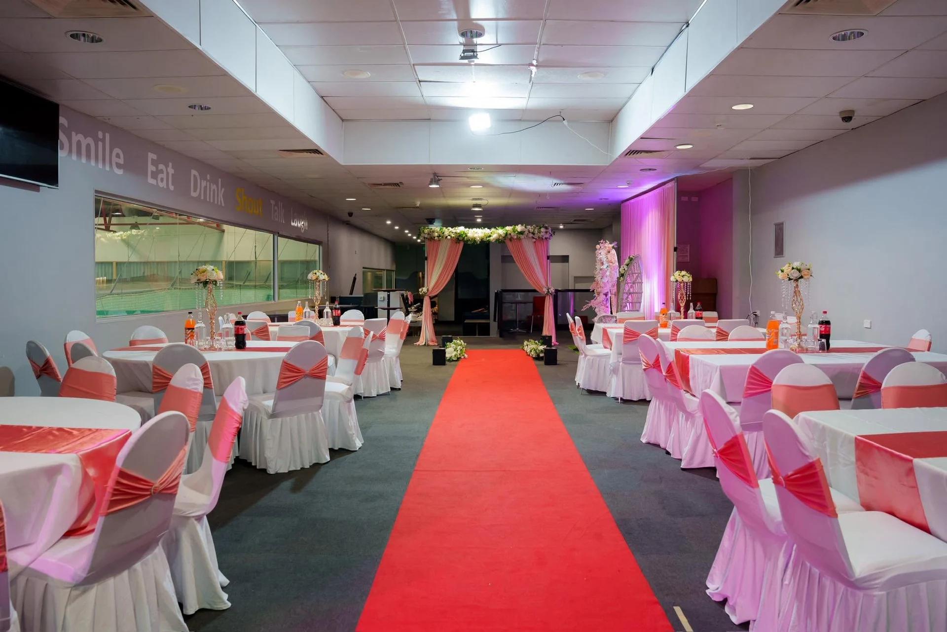A red aisle leads through the KTM banquet room to a floral entrance